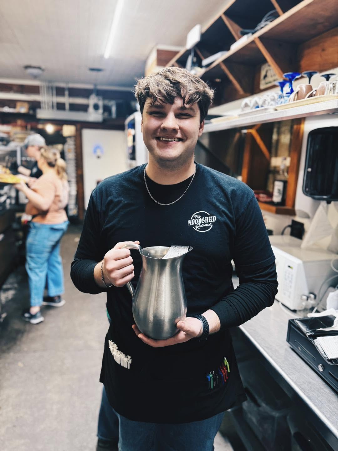 Woodshed team member holding a serving pitcher